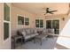 Inviting covered patio with cozy seating area, ceiling fan, and sliding door access to the house at 1915 E Citation Ln, Tempe, AZ 85284
