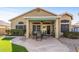 Rear of the house showing the covered patio with seating and well-manicured landscaping at 19185 N 116Th Ln, Surprise, AZ 85378