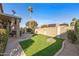 Large backyard with artificial lawn, desert landscaping, and covered patio at 19185 N 116Th Ln, Surprise, AZ 85378