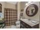 Well-lit bathroom with a shower, toilet, and vanity with a round mirror at 19185 N 116Th Ln, Surprise, AZ 85378