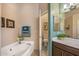 Well-lit bathroom features a soaking tub, neutral tile, and modern fixtures at 19185 N 116Th Ln, Surprise, AZ 85378