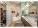 Bright bathroom featuring a soaking tub, walk-in closet, and a modern vanity with dual sinks at 19185 N 116Th Ln, Surprise, AZ 85378