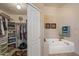 Bathroom featuring soaking tub, open closet and neutral tile at 19185 N 116Th Ln, Surprise, AZ 85378