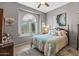 Cozy bedroom showcasing a decorative window, ceiling fan, and comfortable furnishings at 19185 N 116Th Ln, Surprise, AZ 85378