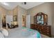 Spacious bedroom with a decorative mirror and a large bed with floral-patterned bedding at 19185 N 116Th Ln, Surprise, AZ 85378