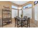 Cozy dining area with a round table, four chairs, natural light from the windows, and a charming bar setup at 19185 N 116Th Ln, Surprise, AZ 85378