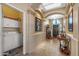 Inviting hallway with tile floors, skylight, and arched doorway leading to a laundry room at 19185 N 116Th Ln, Surprise, AZ 85378