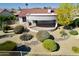 Beautifully landscaped backyard featuring desert landscaping, rock features, and a covered patio, perfect for outdoor relaxation at 20113 N Lagos Ct, Surprise, AZ 85374