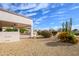 Low maintenance backyard with covered patio, desert landscaping, and blue skies at 20113 N Lagos Ct, Surprise, AZ 85374