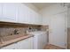 Laundry room features cabinets, counter space, and updated washer and dryer at 20113 N Lagos Ct, Surprise, AZ 85374