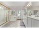 Updated bathroom with double sinks, large mirrors, shower, soaking tub, and access to exterior at 20386 E Bronco Dr, Queen Creek, AZ 85142