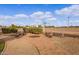 Outdoor firepit with stone benches and walkway and equestrian facilities in the background at 20386 E Bronco Dr, Queen Creek, AZ 85142