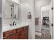 Updated powder room featuring a decorative mirror and dark wood cabinets at 20421 W Legend Trl, Buckeye, AZ 85396