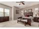 Spacious bedroom with dark wood furniture, neutral paint, ceiling fan, and carpet at 20421 W Legend Trl, Buckeye, AZ 85396