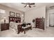 Bedroom with dark wood furniture, ceiling fan, neutral paint, and soft carpeting at 20421 W Legend Trl, Buckeye, AZ 85396