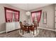 Cozy dining room with wood-style tile flooring, chandelier, and bright window at 20421 W Legend Trl, Buckeye, AZ 85396