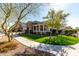 Beautiful single-story home with a stone-accented exterior, charming porch, and lush green lawn at 20421 W Legend Trl, Buckeye, AZ 85396
