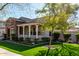 Scenic single-story home featuring a stone-accented exterior, lovely porch, and vibrant green lawn at 20421 W Legend Trl, Buckeye, AZ 85396
