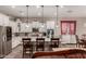 Open kitchen with white cabinetry, granite counters, pendant lights, and breakfast bar seating at 20421 W Legend Trl, Buckeye, AZ 85396