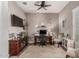 Comfortable home office with ceiling fan, stylish desk, musical instruments and neutral decor at 20421 W Legend Trl, Buckeye, AZ 85396