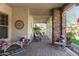Charming covered front porch features ample seating, decorative accents, and a welcoming ambiance at 20421 W Legend Trl, Buckeye, AZ 85396