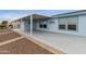 This backyard has a covered patio with gravel and brick landscaping with blue siding and white trim at 2263 N Trekell Rd # 175, Casa Grande, AZ 85122