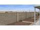 This backyard is enclosed with a tall block wall and is landscaped with gravel and sparse vegetation at 2263 N Trekell Rd # 175, Casa Grande, AZ 85122