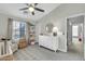 Bright Bedroom featuring a white dresser, crib, and a comfortable chair at 2402 E 5Th St # 1455, Tempe, AZ 85288