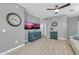 Cozy living room featuring a large clock, entertainment center, and wood flooring at 2402 E 5Th St # 1455, Tempe, AZ 85288