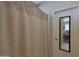 Bathroom showcasing a shower curtain, a door with a mirror, and neutral decor at 2416 N Snead Dr, Mesa, AZ 85215