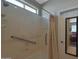 Accessible shower with grab bars and a shower curtain, adjacent to a mirrored door at 2416 N Snead Dr, Mesa, AZ 85215