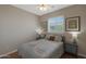 Well-lit bedroom with a ceiling fan, a window, and bedside tables with lamps at 2416 N Snead Dr, Mesa, AZ 85215