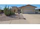 Charming single-story home featuring desert landscaping, a two-car garage, and a cozy front patio with seating at 2416 N Snead Dr, Mesa, AZ 85215