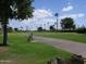 Expansive golf course view featuring lush greenery, manicured fairways, and a scenic walking path lined with palm trees at 2416 N Snead Dr, Mesa, AZ 85215