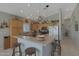 Well-lit kitchen boasts ample wood cabinetry, modern stainless appliances, and a breakfast bar with seating at 2416 N Snead Dr, Mesa, AZ 85215