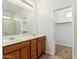 Bathroom featuring double sinks, wood cabinets, and a large mirror with a shower at 2454 E Vermont Dr, Gilbert, AZ 85295