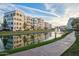 Beautiful view of a community lake reflecting the surrounding buildings and a fountain under a blue sky at 2511 W Queen Creek Rd # 307, Chandler, AZ 85248