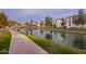 Scenic lakeside view of the community with lush landscaping and walking path at dusk at 2511 W Queen Creek Rd # 307, Chandler, AZ 85248