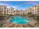 Beautiful community pool featuring lounge chairs and palm trees and beautiful apartment buildings at 2511 W Queen Creek Rd # 307, Chandler, AZ 85248
