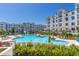 Large community pool with seating and umbrellas surrounded by lush landscaping and beautiful buildings at 2511 W Queen Creek Rd # 307, Chandler, AZ 85248