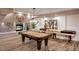 Recreation room with a pool table, shuffleboard, fireplace, hardwood floors and decorative art at 2511 W Queen Creek Rd # 307, Chandler, AZ 85248