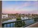 Balcony view of the pond with a fountain, trees, nearby buildings, and a colorful sky at 2511 W Queen Creek Rd # 307, Chandler, AZ 85248