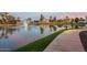 Scenic pond with a fountain and beautiful waterfront walking path lined with grass at 2511 W Queen Creek Rd # 307, Chandler, AZ 85248