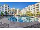 Resort-style pool surrounded by residential buildings with sun loungers and umbrellas at 2511 W Queen Creek Rd # 307, Chandler, AZ 85248