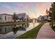 Waterfront community with fountains, modern buildings, and pink sunset reflections at 2511 W Queen Creek Rd # 307, Chandler, AZ 85248