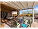 Inviting backyard patio with a pergola, lounge seating, and a well-maintained desert landscape at 26057 W Sequoia Dr, Buckeye, AZ 85396