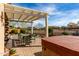 Scenic backyard patio with a hot tub, comfortable seating, and a lush desert landscape at 26057 W Sequoia Dr, Buckeye, AZ 85396