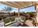 Relaxing backyard patio with a hot tub, outdoor seating, and landscaped desert scenery at 26057 W Sequoia Dr, Buckeye, AZ 85396