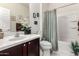 Bathroom featuring a vanity with sink, toilet, and bathtub with a shower curtain at 26057 W Sequoia Dr, Buckeye, AZ 85396