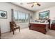 Bright bedroom with a ceiling fan, large window with blinds, and a comfortable-looking bed at 26057 W Sequoia Dr, Buckeye, AZ 85396
